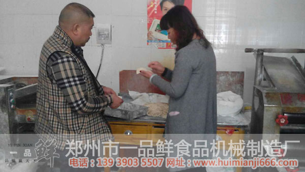 工作人員給陳先生講解機(jī)器出面的優(yōu)點(diǎn)